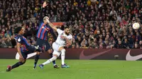 Striker Real Madrid, Karim Benzema melepaskan tendangan yang menghasilkan gol keempat timnya ke gawang Barcelona pada laga leg kedua semifinal Copa del Rey 2022/2023 di Camp Nou Stadium, Barcelona, Kamis (6/4/2023) dini hari WIB. (AFP/Pau Barrena)