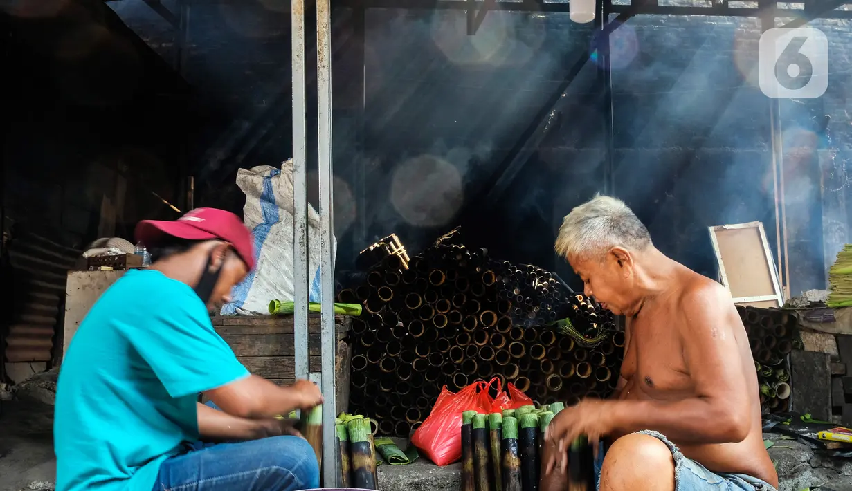 Pekerja memasukan beras ke dalam bambu yang dibungkus daun pisang di industri pembuatan lemang kawasan Senen, Jakarta, Selasa (27/4/2021). Untuk satu batang lemang dijual Rp 15.000 ke penjual makanan yang kemudian dijual kembali Rp 30.000 per batang kepada konsumen.  (Liputan6.com/Johan Tallo)