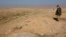 Anggota Kurdi Peshmerga memeriksa sebuah kuburan massal yang diduga lokasi makam anggota Yazidi Irak di pinggiran Sinjar, 30 November 2015. Pasukan Kurdi menemukan kuburan ini usai berhasil merebut kembali kota Irak dari militan ISIS. (Reuters/Ari Jalal)
