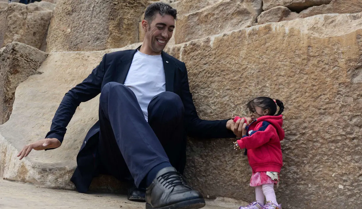 Jyoti Amge dan Sultan Kosen melakukan sesi pemotretan di Piramida Giza, Mesir (26/1). Jyoti Amge dan Sultan Kosen diundang Dewan Pariwisata Mesir untuk berkunjung ke tempat-tempat paling terkenal di Kairo agar meningkatkan pariwisata. (AFP Photo/Stringer)