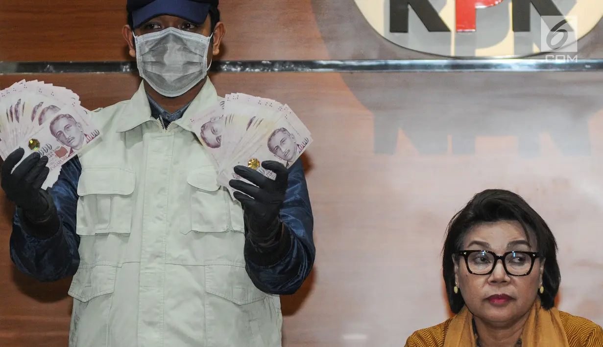 Petugas KPK disaksikan Wakil Ketua KPK Basariah Panjaitan menunjukkan barang bukti uang SGD 96.700 hasil OTT di Gedung KPK, Kamis (1/8/2019). Uang tersebut diduga terkait suap proyek pengadaan baggage handling system (BHS) atau sistem penanganan bandara untuk 6 bandara. (merdeka.com/Dwi Narwoko)