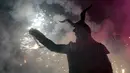 Seorang warga berpakaian seperti hantu dengan memegang tongkat kembang api selama perayaan " Correfocs ", Mallorca, Spanyol, (24/1). Ini merupakan perayaan tradisional yang menandai menandai akhir dari perayaan lokal di Palma. (REUTERS / Enrique Calvo)