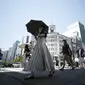 Orang-orang berjalan di atas penyeberangan pejalan kaki di bawah terik matahari di Tokyo, Selasa (28/6/2022). Pemerintah Jepang mengeluarkan peringatan untuk kemungkinan pemadaman listrik di wilayah Tokyo pada hari Senin (27/6), meminta kantor dan penduduk untuk menghemat energi karena wilayah ibu kota dilanda panas terik. (AP Photo/Eugene Hoshiko)