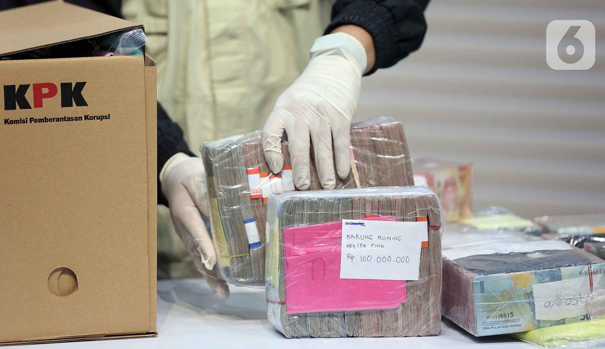 Petugas menyusun tumpukan uang barang bukti Operasi Tangkap Tangan (OTT) Bupati Pati Sudewo di Gedung Merah Putih Komisi Pemberantasan Korupsi (KPK), Jakarta, Selasa (20/1/2026). KPK menyita uang tunai dalam mata uang rupiah senilai Rp2,6 miliar dalam Operasi Tangkap Tangan (OTT) Bupati Pati Sudewo. (Liputan6.com/Helmi Fithriansyah)