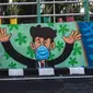 Warga berpose dengan mural yang mengajak orang untuk memakai masker di tengah pandemi Covid-19 di Surabaya, Jawa Timur, Minggu (25/10/2020). Mural di sepanjang dinding itu sebagai sarana imbauan kepada masyarakat untuk menerapkan protokol kesehatan pencegahan penularan COVID-19. (Juni Kriswanto/AFP)