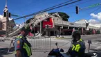 Polisi berkumpul di depan reruntuhan restoran cepat saji Jollibee setelah gempa bumi berkekuatan magnitudo 7,8 di Kota General Santos, Filipina, pada Senin 8 Juni 2026. (Edwin Espejo/AFP)