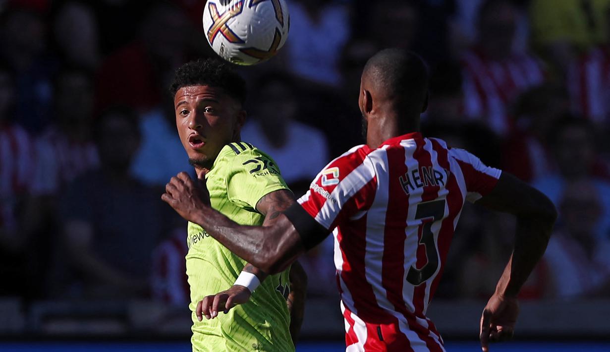 Penyerang Manchester United, Jadon Sancho (kiri) berebut bola dengan bek Brentford, Rico Henry selama pertandingan lanjutan Liga Inggris di Gtech Community Stadium di London, Sabtu (13/8/2022). Brentford menang telak atas MU 4-0. (AFP Photo / Ian Kington)