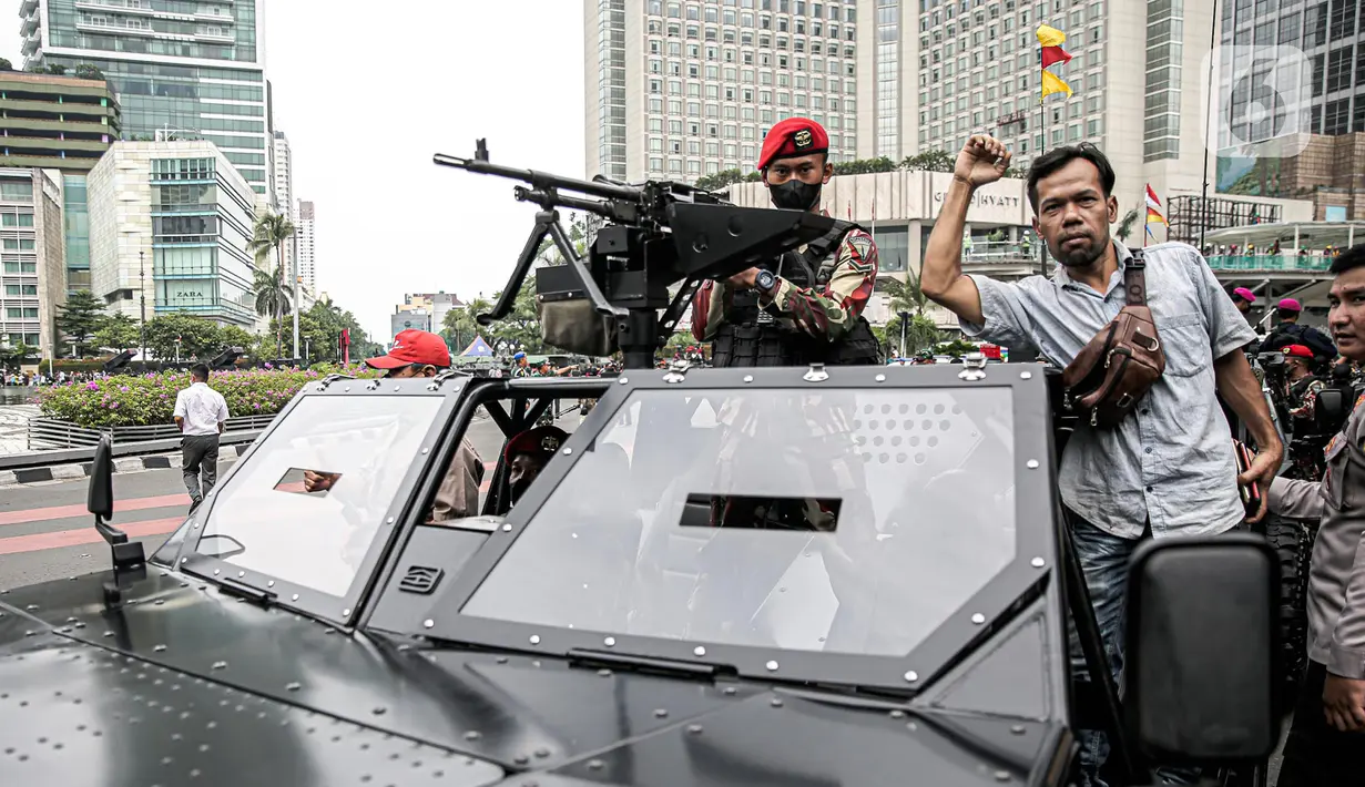 Warga berfoto dengan tentara dan alat utama sistem senjata (alutsista) milik TNI saat perayaan HUT ke-77 TNI di Bundaran HI, Jakarta, Rabu (5/10/2022). Kegiatan yang diikuti oleh seluruh kesatuan jajaran TNI ini dalam rangka menyambut HUT ke-77 TNI. (Liputan6.com/Faizal Fanani)