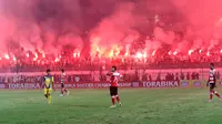Suporter Madura United, menyalakan flare memperingati HUT membuat laga melawan Persiba Balikpapan tertunda pada Torabika SC2016 di Stadion Gelora Bangkalan, Senin(13/6/2016).  (Bola.com/Nicklas Hanoatubun)