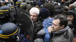 Polisi anti huru-hara terlibat saling dorong dengan pengunjuk rasa sehari setelah pemilihan presiden Prancis, Senin (8/5). Mereka menduga suara mereka tidak masuk ke dalam kotak suara yang memenangkan Emmanuel Macron. (AFP Photo/ Lionel BONAVENTURE)