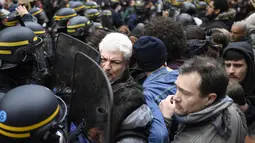 Polisi anti huru-hara terlibat saling dorong dengan pengunjuk rasa sehari setelah pemilihan presiden Prancis, Senin (8/5). Mereka menduga suara mereka tidak masuk ke dalam kotak suara yang memenangkan Emmanuel Macron. (AFP Photo/ Lionel BONAVENTURE)