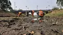 Petugas UPK Badan Air Dinas Lingkungan Hidup Provinsi DKI Jakarta membersihkan rerumputan dan sampah di dasar aliran Kanal Banjir Timur, Jakarta, Rabu (7/8/2019). Kemarau berkepanjangan mengakibatkan debit air Kanal Banjir Timur menyusut hingga dasar aliran terlihat. (merdeka.com/Iqbal Nugroho)