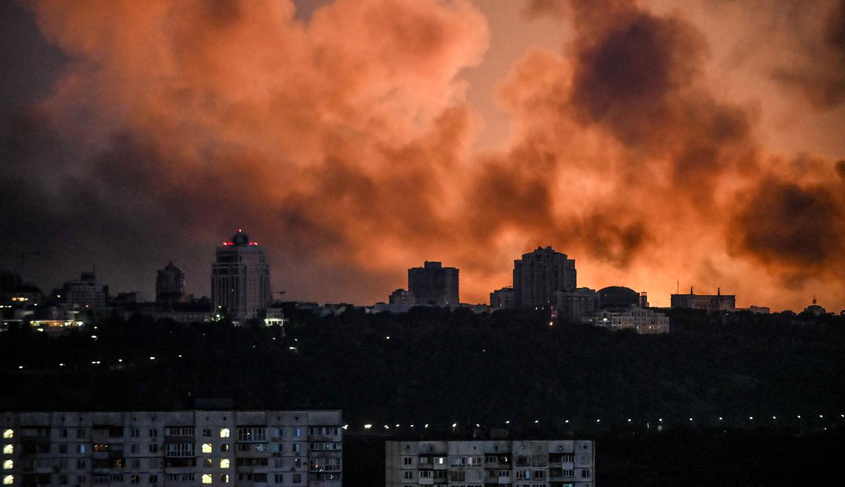 Asap mengepul saat cahaya dari api menerangi langit selama serangan Rusia di ibu kota Ukraina, Kyiv, pada Minggu 24 Mei 2026, di tengah invasi Rusia di Ukraina. (Evgen KOTENKO/AFP)