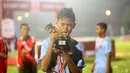 Pemain Terbaik Rusun Cup 2015 dari Rusun Daan Mogot, Mohammad Sobri, berpose dengan pialanya seusai laga final di Stadion Soemantri Brojonegoro, Jakarta, Minggu (8/11/2015). ( Bola.com/Nicklas Hanoatubun)