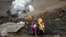 Warga berebut uang dan hasil bumi yang dilemparkan dari bibir kawah Gunung Bromo, Probolinggo, Kamis (21/7). Warga Tengger melakukan ritual lempar hasil bumi sebagai wujud syukur pada Sang Hyang Widi. (Liputan6.com/Helmi Fithriansyah)