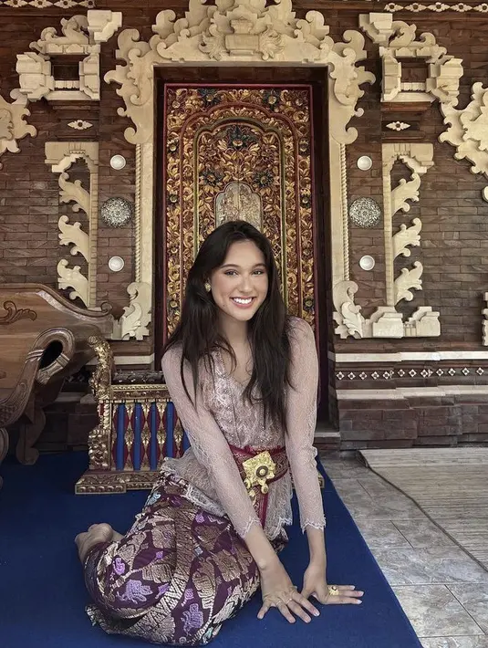 Yasmin Napper tampil dengan kebaya khas Bali warna keunguan yang dipadukan kain songket dan belt lengkap dengan bros keemasan. Credit: Instagram (@yasminnapper)