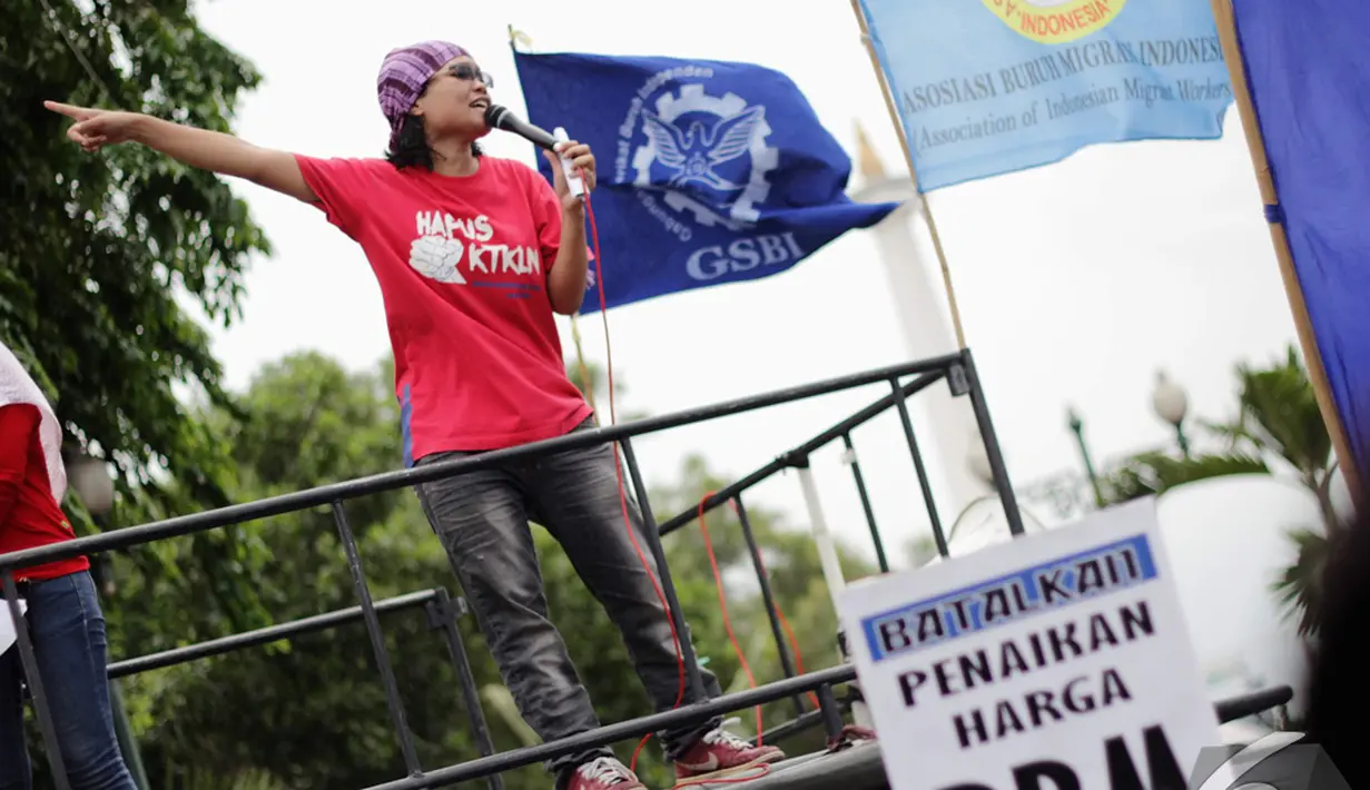Seorang buruh wanita berorasi menuntut Jokowi untuk melindungi para buruh migran saat aksi di Istana Negara, Jakarta, Kamis (18/12/2014). (Liputan6.com/Faizal Fanani)