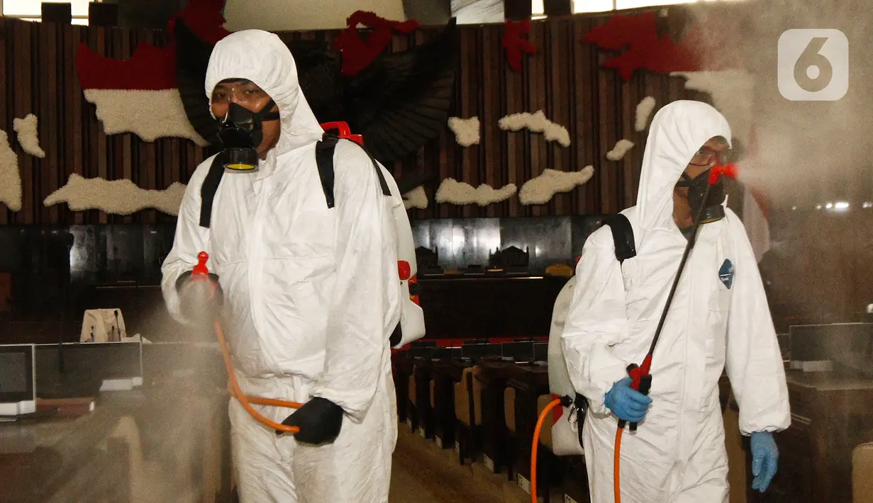 Petugas melakukan penyemprotan cairan disinfektan di area ruang rapat paripurna di Gedung Nusantara, Kompleks Parlemen MPR/DPR-DPD, Senayan, Jakarta, Minggu (29/3/2020). Penyemprotan disinfektan ini juga untuk mencegah penyebaran wabah corona (Covid-19). (Liputan6.com/Johan Tallo)