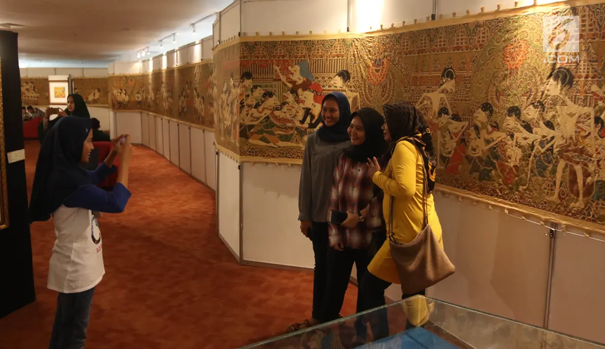 Pengunjung berfoto dengan latar belakang karya-karya Panji dalam Festival Panji Internasional di Perpustakaan Nasional, Jakarta, Selasa (10/7). Pameran Panji tersebut berlangsung hingga 11 Juli 2018. (Liputan6.com/Arya Manggala)