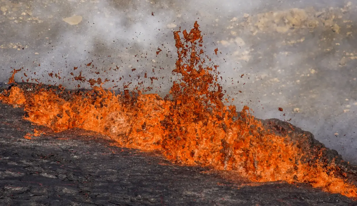 Tampilan close-up lava yang mengalir dari gunung berapi Fagradalsfjall di Islandia pada Rabu (3/8/2022), yang terletak 32 kilometer (20 mil) barat daya ibu kota Reykjavik dan dekat dengan Bandara Internasional Keflavik. Meski begitu, bandara tetap buka dan tidak ada penerbangan yang terganggu. (AP Photo/Marco Di Marco)
