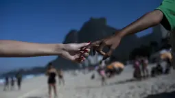 Selama acara berlangsung, para sukarelawan termasuk anak-anak memungut sampah dari pantai Sao Conrado. (AP Photo/Bruna Prado)