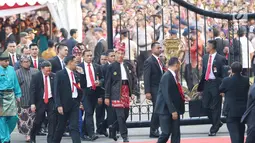 Presiden Joko Widodo atau Jokowi berjalan keluar menuju tribune dekat pagar Istana Merdeka, Jakarta, Kamis (17/8). Jelang penurunan bendera pusaka, Jokowi tiba-tiba keluar dan menemui masyarakat yang berdiri di luar Istana. (Liputan6.com/Angga Yuniar)