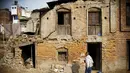 Seorang pria berdiri di luar rumahnya yang rusak akibat gempa tahun lalu di Nepal, Jum'at (29/1/2016). Gempa bumi pada bulan April dan Mei 2015 silam menewaskan hampir 9.000 orang dalam bencana alam terburuk Nepal. (Reuters/Navesh Chitrakar)