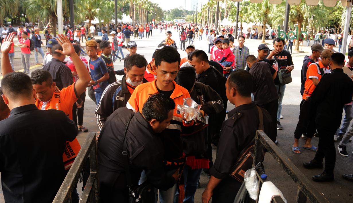 Ratusan The Jakmania ikuti pemeriksaan saat memasuki stadion sebelum menonton Piala AFC 2018 antara Persija Jakarta vs Song Lam Nghe An di Stadion Utama GBK, Rabu (14/3/2018). Panpel menjual sekitar 65.000 lembar tiket. (Bola.com/Surya Bima Mahendarta)
