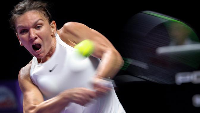 Petenis Rumania, Simona Halep memukul bola ke arah lawannya petenis Kanada, Bianca Andreescu selama turnamen WTA Finals 2019 di Shenzhen, China, Senin (28/10/2019). Halep memetik kemenangan atas petenis muda Kanada yang sensasional, Bianca Andreescu 3-6, 7-6, 6-3. (AP/Andy Wong)