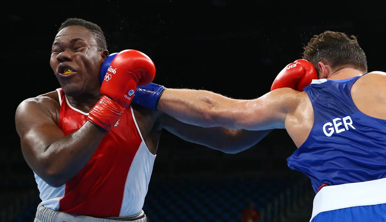 Petinju asal AS, Clayton Laurent terkena pukulan dari Erik Pfeifer asal Jerman saat bertarung di Olimpiade Rio 2016 pada 9 Agustus 2016. (REUTERS/ Peter Cziborra)