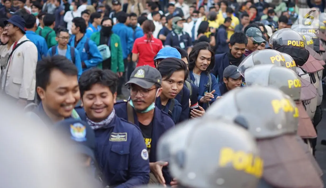 Massa dari Badan Eksekutif Mahasiswa Seluruh Indonesia (BEM SI) bersalaman dengan polisi saat aksi unjuk rasa di sekitar DPR RI, Jakarta, Selasa (1/10/2019). Aksi damai itu berakhir dengan mahasiswa yang bersalaman dan membagikan bunga kepada para polisi yang berjaga (Liputan6.com/Immanuel Antonius)