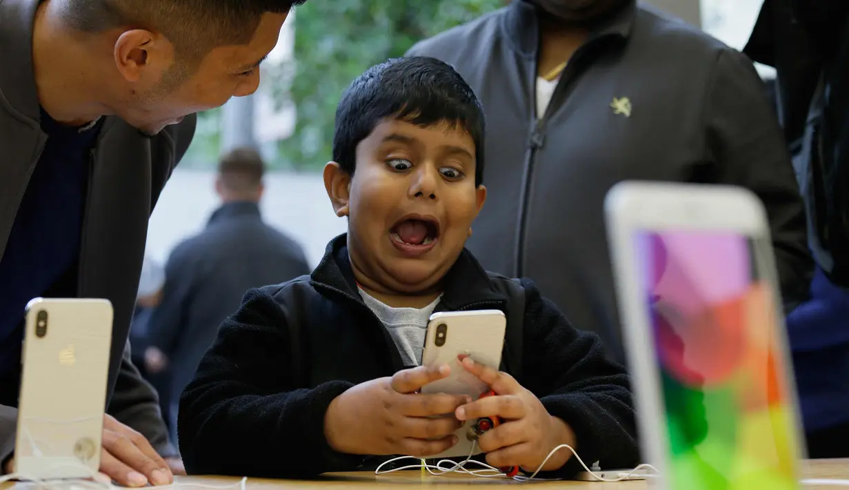 Seorang anak bermain fitur animoji iPhone X di toko Apple Union Square di San Francisco (3/11). iPhone X juga memiliki fitur terbaru Face ID yang berfungsi mendeteksi dan mengenali wajah pemilik sebagai kunci membuka perangkat. (AP Photo/Eric Risberg)