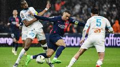 Pemain Paris Saint-Germain, Kylian Mbappe, berebut bola dengan pemain Marseille, Geoffrey Kondogbia, dalam duel pekan ke-27 Ligue 1 2023/2024 di Stade Velodrome, Senin (1/4/2024). PSG menang dengan skor 2-0. (AFP/Christophe Simon)