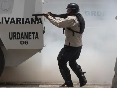 Petugas menembakan peluru karet ke arah anggota oposisi saat bentrokan di Caracas, Venezuela, (4/4). Para demonstran berusaha untuk menemani anggota parlemen oposisi dalam sesi wacana penghapusan Mahkamah Agung. (AP Photo / Ariana Cubillos)