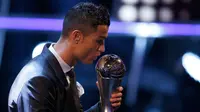 Bintang Real Madrid, Cristiano Ronaldo mencium trofi penghargaan pemain terbaik dalam acara The Best FIFA Football Awards 2017 di London, Senin (23/10). Ronaldo terpilih sebagai pemain terbaik menyisihkan Lionel Messi dan Neymar Junior (AP/Alastair Grant)