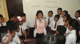 Mantan none Jakarta menjelaskan kepada murid  SDN 01 Pagi Tegal Parang saat Hardiknas, Jakarta, Senin (2/5). Sebanyak 12 Alumni berperan sebagai inspirator untuk 192 siswa dan siswi. (Liputan6.com/Gempur M Surya)