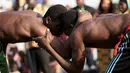 Dua pegulat bersiap untuk memulai pertarungan selama festival gulat tradisional di Bamako, Mali, 7 April 2019. Festival gulat ini memiliki banyak penggemar, terutama kaum lelaki. (MICHELE CATTANI/AFP)