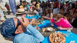 Para peserta beradu cepat memakan daging kepiting batu dalam kontes Key Fisheries Stone Crab Eating di Marathon, Florida, Sabtu (10/11). Mereka harus memecahkan cangkang 25 kepiting batu lalu memakan dagingnya. (Andy Newman/Florida Keys News Bureau/AFP)