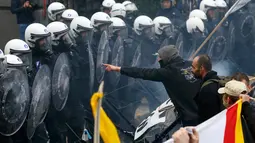 Polisi berjaga-jaga saat aksi menolak Reformasi Pensiun di Brussels, Belgia, Selasa (15/11). Mereka menolak rencana pemerintah yang akan menaikkan usia pensiun dari 56 menjadi 63 tahun. (REUTERS / Yves Herman)