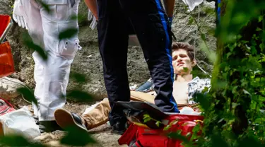 Seorang pemuda yang terluka parah menerima bantuan medis setelah mengalami luka akibat ledakan di Central Park, New York, Minggu (3/7). Kaki kirinya hampir putus akibat ledakan yang masih diselidiki sumber penyebabnya. (Kena Betancur/AFP)