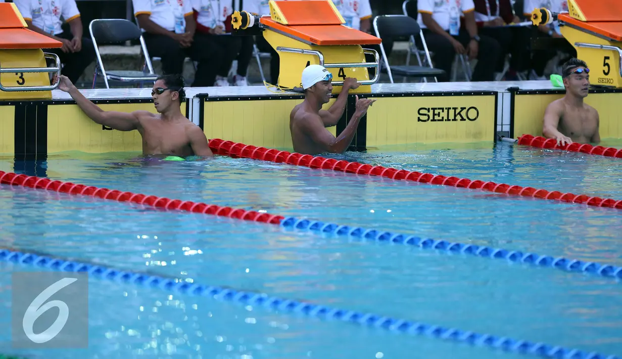 Perenang Jawa Barat, Triadi Fauzi S (kiri) melompat saat lomba di kelas 100m gaya bebas putra di Gelanggang Renang FPOK UPI, Bandung, Senin (19/9). Triadi meraih emas sekaligus memecahkan rekor PON dengan 50,49 dtk. (Liputan6.com/Helmi Fithriansyah)