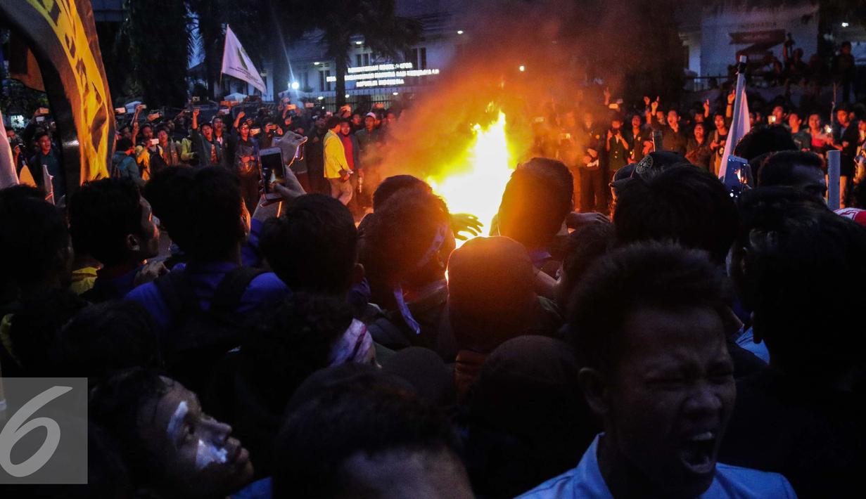 Massa aksi membakar ban saat menggelar aksi unjuk rasa di depan Istana Negara, Kamis (12/1). Namun mahasiswa bertahan dan menuntut ditemui langsung oleh Presiden Joko Widodo. (Liputan6.com/Faizal Fanani)