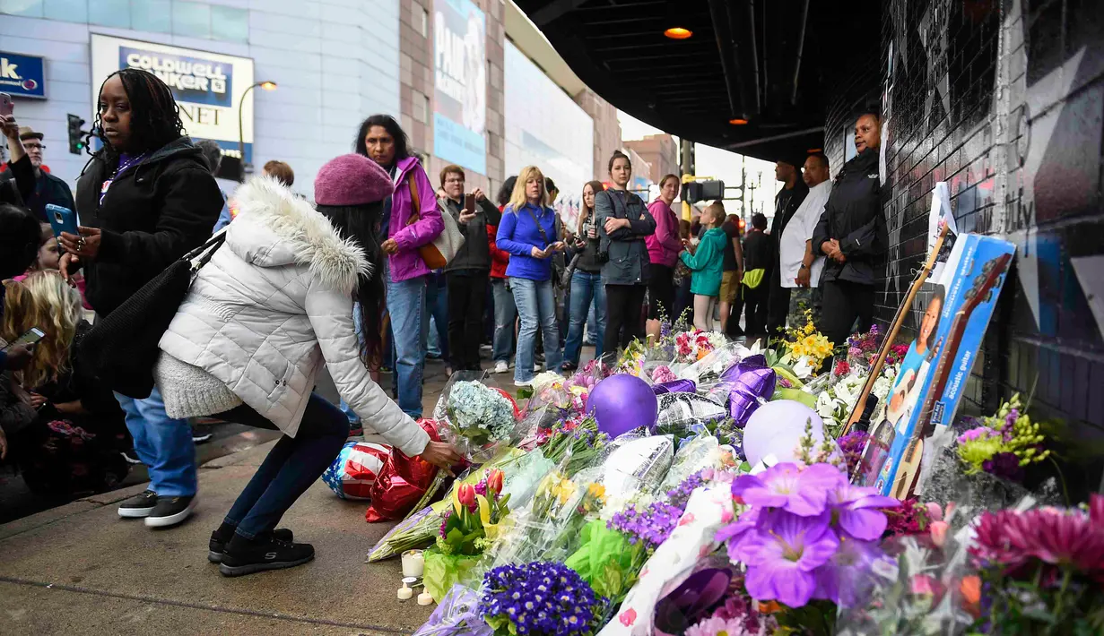 Penggemar meletakkan karangan bunga di luar First Avenue, klub malam dimana penyanyi legendaris dunia, Prince, memulai kariernya di Minneapolis, Minnesota, Kamis (21/4). Prince ditemukan meninggal dunia pada usia 57 tahun. (REUTERS/Craig Lassig)