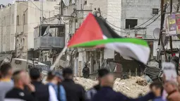 Sementara, militer Israel menetapkan kamp tersebut sebagai zona tertutup, yang melarang siapapun masuk atau keluar tanpa izin khusus. Tampak dalam foto, warga Palestina berunjuk rasa setelah tentara Israel memblokir pintu masuk kamp pengungsi Palestina Nur Shams di Tepi Barat yang diduduki pada Senin 9 Februari 2026. (Jaafar ASHTIYEH/AFP)