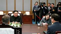 Pemimpin Korea Utara Kim Jong Un (kiri) berbicara dengan Presiden Korea Selatan Moon Jae-in di Peace House, Panmunjom, Korea Selatan, Jumat (27/4). Kedua negara akan membahas terkait senjata nuklir Korea Utara. (Korea Summit Press Pool via AFP)