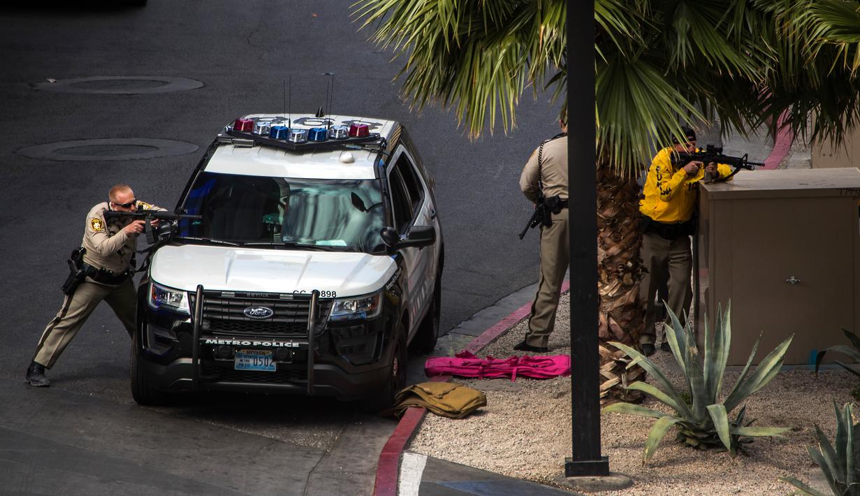 Tim SWAT mengepung pelaku penembakan di dekat hotel sekaligus kasino terkemuka Cosmopolitan, Las Vegas, Sabtu (25/3). Pria bertopeng babi tiba-tiba mengeluarkan tembakan dan membuat para turis melarikan diri dari hotel. (L.E. Baskow/Las Vegas Sun via AP)