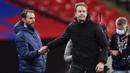 Manajer Inggris Gareth Southgate (kiri) berjabat tangan dengan Manajer Denmark Kasper Hjulmand usai pertandingan UEFA Nations League di Stadion Wembley, London, Inggris, Rabu (14/10/2020). Denmark menang 1-0. (Toby Melville/Pool via AP)
