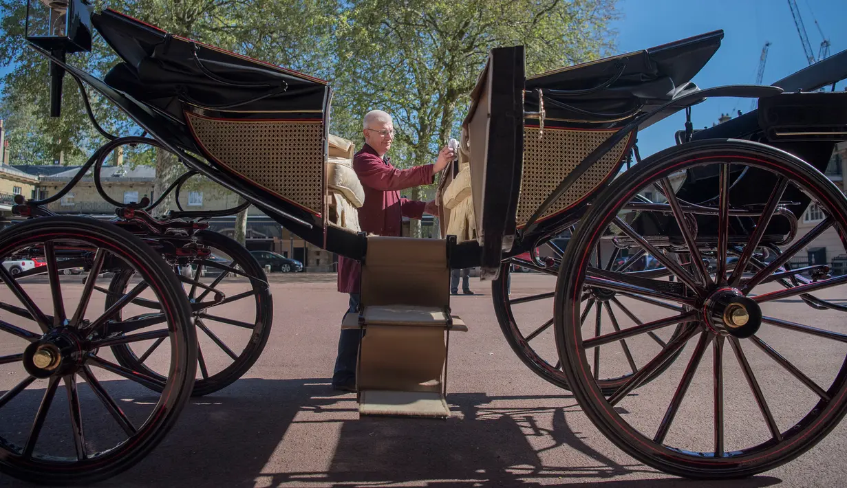 Senior Carriage Restorer, Martin Oates, memoles kereta kencana Ascot Landau yang akan digunakan Pangeran Harry dan Meghan Markle di Istana Buckingham, London, Selasa (2/5). Ascot Landau hanya akan digunakan jika cuaca cerah. (Victoria Jones/Pool via AP)