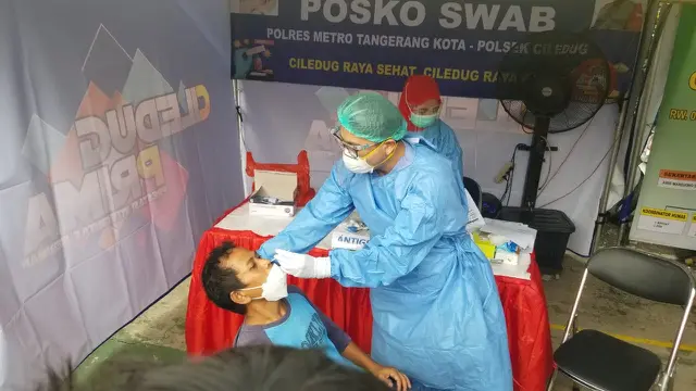 Salah seorang warga Kota Tangerang yang kembali dari kampung halaman di tes swab antigen oleh petugas medis. (Liputan6.com/Pramita Tristiawati)