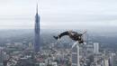 Seorang pelompat BASE terjun dari Menara Kuala Lumpur selama KL Tower International Jump Malaysia di Kuala Lumpur, Jumat (3/2/2023). BASE adalah akronim untuk empat jenis objek tetap yang bisa diambil oleh para jumper dalam olahraga, termasuk bangunan, antena, bentang (yang mencakup jembatan), dan Bumi (seperti bagian atas tebing). (AP Photo/Vincent Thian)